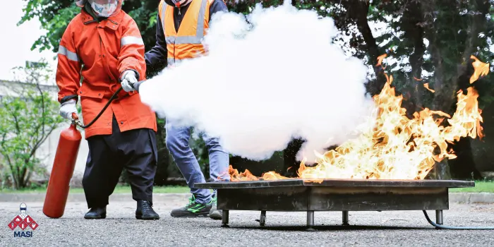 Toma visual de una brigada de seguridad en plena capacitación práctica, utilizando extintores bajo supervisión experta y seguridad industrial